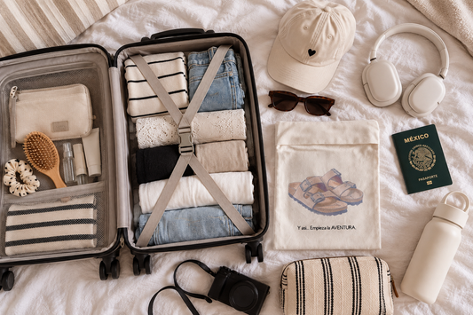 Maleta de mano abierta sobre la cama con ropa enrollada, neceser, pasaporte, audífonos y bolsa para zapatos TDMAccessories para un fin de semana